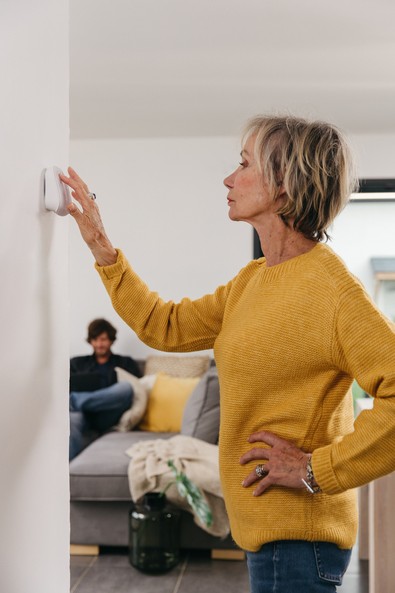 woman regulating thermostat