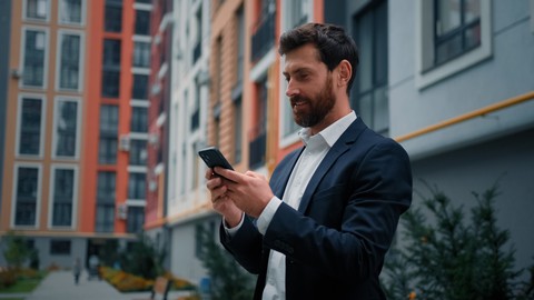 business man checking his smartphone in the street