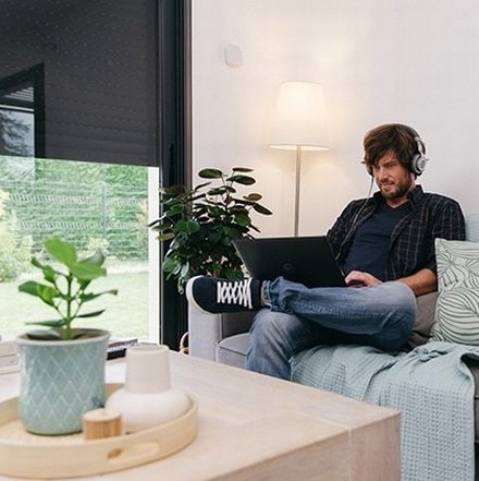 man sitted on a sofa with his laptop