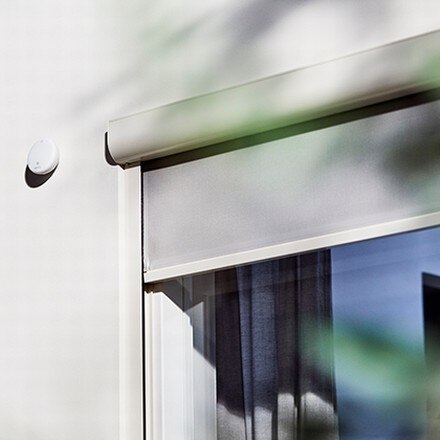 somfy sun sensor on a facade with a screen